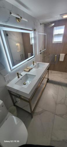 a bathroom with two sinks and a large mirror at Green Island Inn in Fort Lauderdale