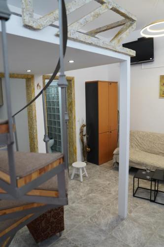 a living room with a staircase and a bedroom at Flowers Lullaby Loft in Afantou