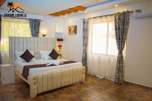 Un dormitorio con una cama grande y una ventana en Shikari Luxville, en Vipingo