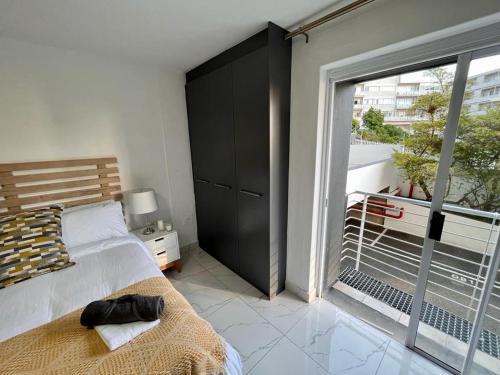 Un dormitorio con una cama y una ventana grande. en Trendy Green Point Retreat, en Ciudad del Cabo