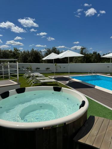uma banheira de hidromassagem num quintal ao lado de uma piscina em Jasmine Hotel em São Pedro de Alva