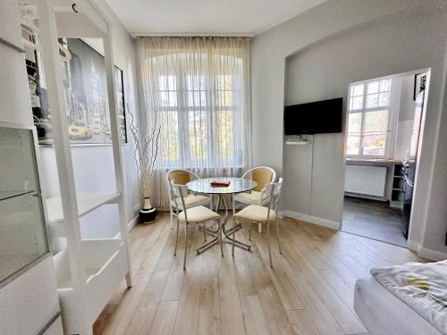 a kitchen and dining room with a table and chairs at Przy plaży Apartament BURZA in Międzyzdroje