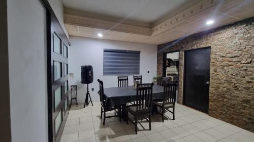 d'une salle à manger avec une table, des chaises et un mur en briques. dans l'établissement Casa Champaya, à Tampico