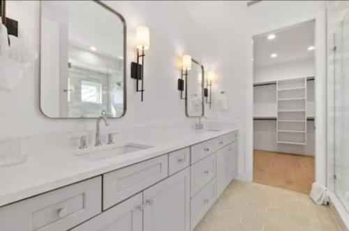 a white bathroom with two sinks and a mirror at Ocean Retreat Pool, Bbq, Short Walk To Beach in Saint Augustine Beach