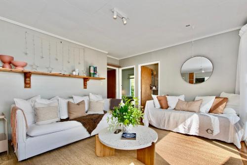 - un salon avec un canapé blanc et une table dans l'établissement Kereru Cottage - Matapouri Holiday Home, à Whangarei
