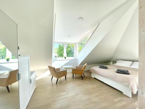 een witte slaapkamer met een bed, een bureau en stoelen bij Luxury Central Apartment Easy Kaunas in Kaunas