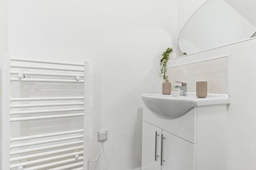 y baño blanco con lavabo y ducha. en New 2 Bedroom Apartment in Burton en Burton upon Trent