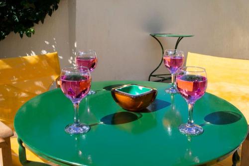 four wine glasses sitting on a green table at traditional village house in Ariokhórion
