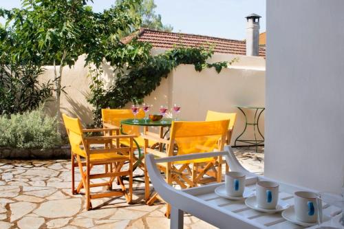 a patio with chairs and a table with drinks on it at traditional village house in Ariokhórion
