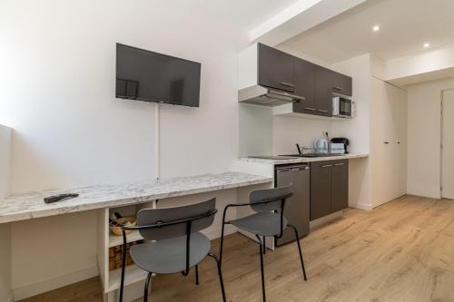une cuisine avec un comptoir et des tabourets dans une pièce dans l'établissement Comfortable and quiet studio, à Toulouse