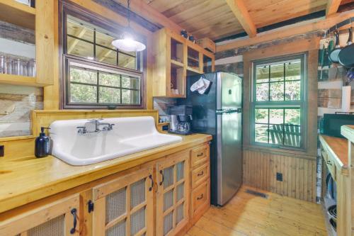 eine Küche mit einer Spüle und einem Kühlschrank in der Unterkunft Restored Buchanan Log Cabin on 9-Mile Creek! in Reba