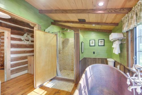 a bathroom with a shower with green walls and a tub at Restored Buchanan Log Cabin on 9-Mile Creek! in Reba