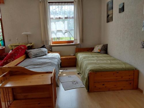 a bedroom with two beds and a window at Alpenblick in Nordschwaben