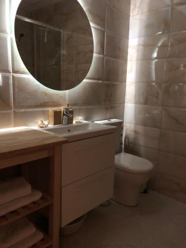 a bathroom with a sink and a mirror and a toilet at Zeka in Kruševac