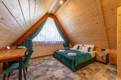 - une chambre dans une cabane en rondins avec un lit et un bureau dans l'établissement Willa Folk Prestige, à Zakopane
