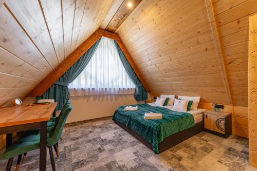 a bedroom in a log cabin with a bed and a desk at Willa Folk Prestige in Zakopane