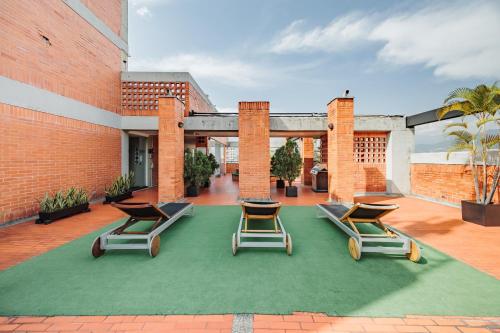 un gruppo di sedie a sdraio su un patio di Orange Suites by Vibra Bonita a Medellín