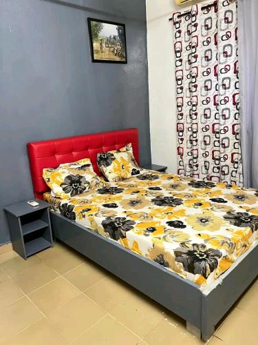 a bedroom with a bed with a red headboard at As résidence meubles k in Ouagadougou