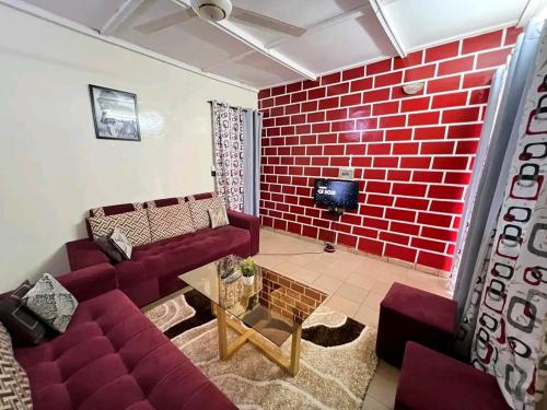 sala de estar con sofá y pared de ladrillo en As résidence meubles k en Uagadugú