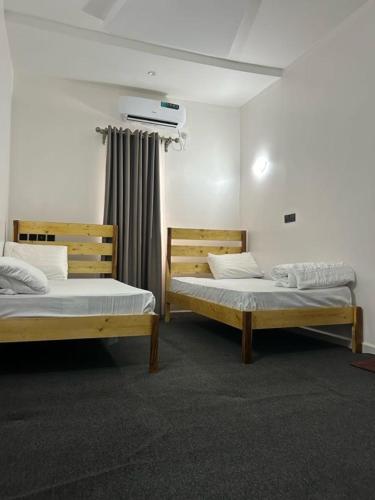 Zwei Betten befinden sich in einem Zimmer mit Fenster. in der Unterkunft Private room in Rayfied, Jos in Jos