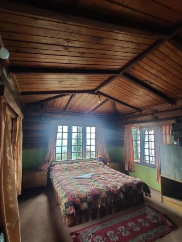 a bedroom with a bed in a room with windows at Mt.Narsing Village Resort in Ravangla