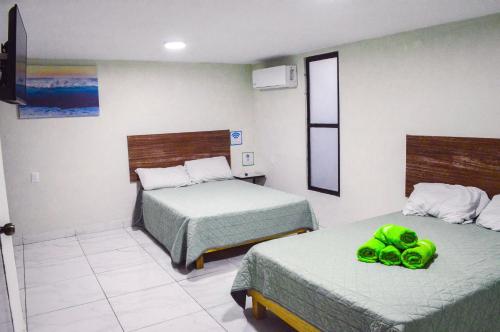 a room with two beds with green shoes on them at Posada Vacacional Brisas del Mar in Mazatlán