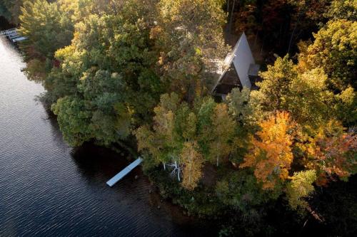 una vista aérea de un río con árboles y una casa en Tranquil Waterside Barn Escape en Oakwood