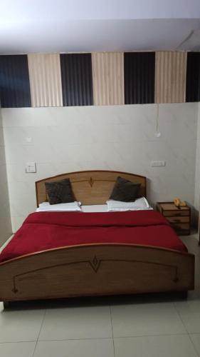 1 dormitorio con 1 cama grande con manta roja en Hotel Batra, en Ludhiana