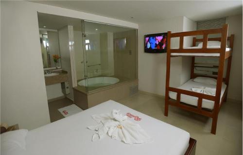 a bedroom with a bunk bed and a bathroom at Hotel Romanza in Medellín