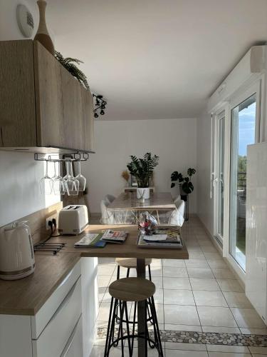une cuisine avec un comptoir et une table avec des tabourets dans l'établissement Appartement T2, à Vannes