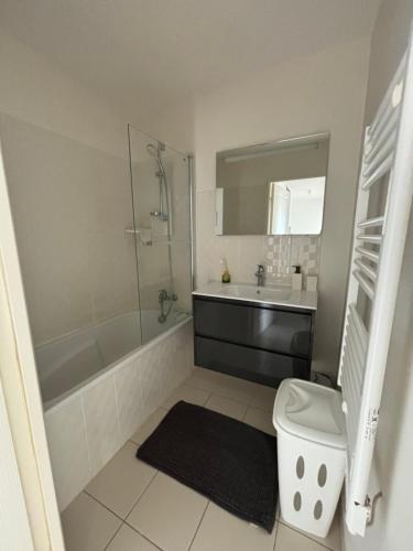 une salle de bain avec une baignoire, un lavabo et des toilettes dans l'établissement Appartement T2, à Vannes