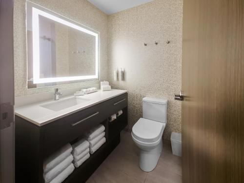 a bathroom with a sink and a toilet and a mirror at Home2 Suites By Hilton Bolingbrook Chicago in Bolingbrook
