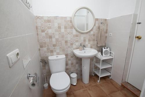 a bathroom with a toilet and a sink and a mirror at El Olmo in Posadas