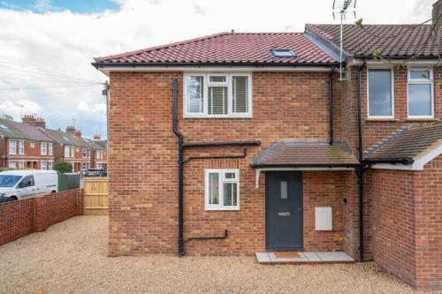 a red brick house with a black door at North Horsham House in Horsham