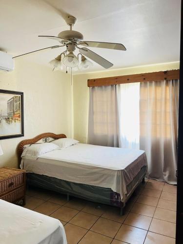 1 dormitorio con 2 camas y ventilador de techo en villa en palma real, en La Ceiba