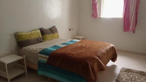 een slaapkamer met een bed met een kleurrijke deken bij حي الهناء 2 