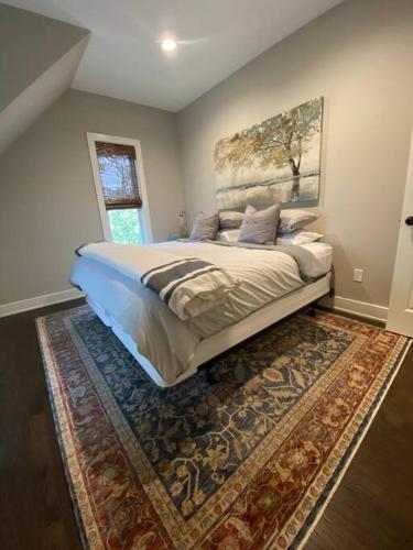 a bedroom with a large bed and a rug at Carriage House on Historic Bentonville Square in Bentonville