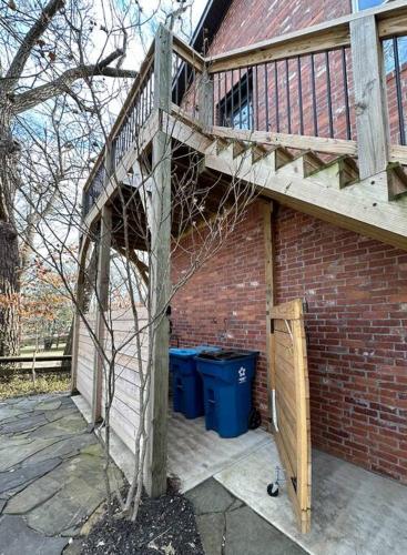 a brick building with a staircase and two trash cans at Carriage House on Historic Bentonville Square in Bentonville