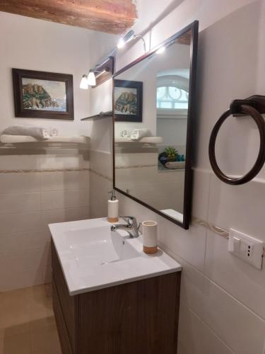 La salle de bains est pourvue d'un lavabo et d'un miroir. dans l'établissement Cà da Ro, à Fezzano
