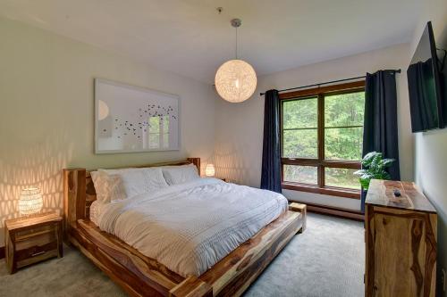 a bedroom with a bed and a large window at Tremblant Prestige - Étoile 1510-23 in Mont-Tremblant