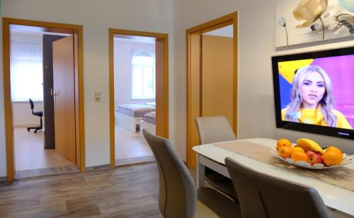 une salle à manger avec une table avec un bol de fruits dessus dans l'établissement Urlaub nicht nur für Monteure "G1", à Gera