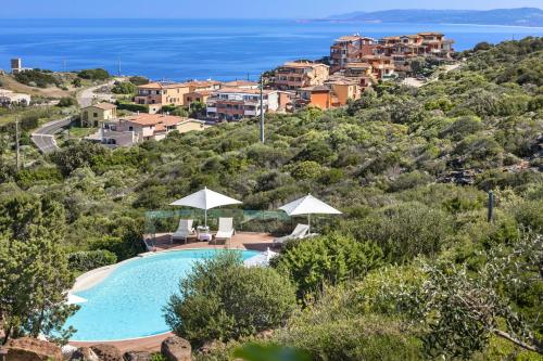 a villa with a pool and a view of the ocean at Il Borgo BagaBaga - Exclusive Country Retreat in Castelsardo