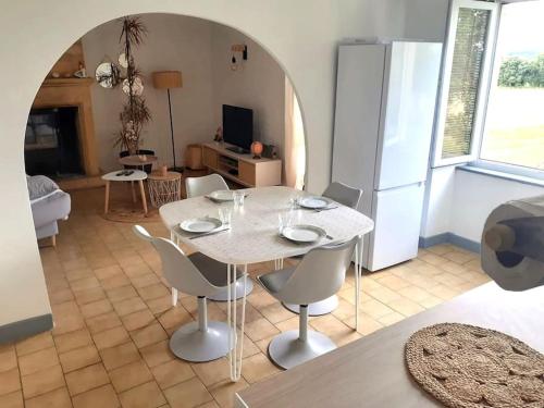 une salle à manger avec une table et des chaises et une cuisine dans l'établissement Gîte à deux pas de Sarlat Calme et paisible, à Proissans