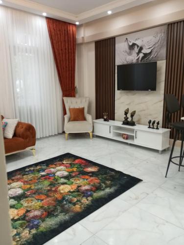 a living room with a television and a flower rug at Kiralık daire in Yalova