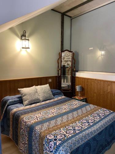 a bedroom with a bed and a mirror and lights at APARTAMENTO ESTUDIO AS ANDURIÑAS in San Martín de Trevejo