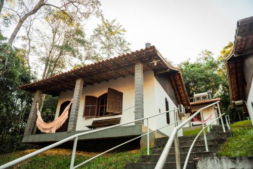 Cette petite maison blanche dispose d'une terrasse couverte et d'escaliers. dans l'établissement Pousada Tapera, à Penedo