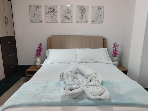 een slaapkamer met een bed met handdoeken erop bij Apartamentos Florida Nueva estadio in Medellín