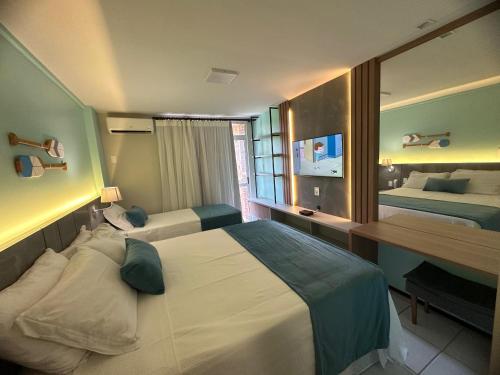 a hotel room with two beds and a desk at Gran Lençois Resort in Barreirinhas