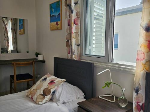 a bedroom with a bed and a window at Ammos Beachfront Villa Paradise in Larnaka