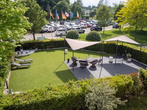 科萊奇奧的住宿－德頓納商務酒店，享有公园空中美景,设有长椅和帐篷